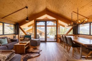 a dining room and living room with a table and chairs at Alpenchalets Reiteralm by ALPS RESORTS in Schladming