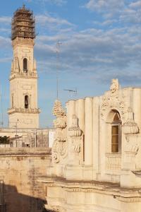 um edifício com uma torre de relógio e um edifício com um céu em Palazzo Zimara Boutique Hotel em Lecce