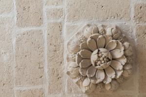 a stone flower on the wall of a building at Palazzo Zimara Boutique Hotel in Lecce