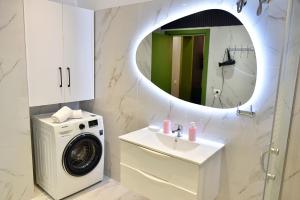 a bathroom with a washing machine and a sink at Vila Noar in Vlorë