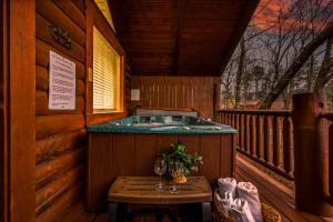 een jacuzzi op een terras in een hut bij Log Cabin, Hot Tub, Fireplace, Pool Table & Views! in Sevierville