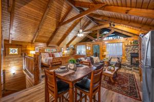 een eetkamer en een woonkamer in een blokhut bij Log Cabin, Hot Tub, Fireplace, Pool Table & Views! in Sevierville