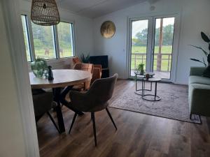 een woonkamer met een tafel en stoelen bij IJsvogel in Schipborg