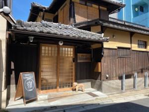 un cane seduto di fronte a un edificio di Kyoto - Hotel - Vacation STAY 83559v a Kyoto