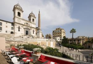 um grupo de mesas e cadeiras em frente a um edifício em Il Palazzetto em Roma