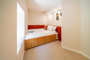 Cette petite chambre comprend un lit et une fenêtre. dans l'établissement Boutique Townhouse, à Westport