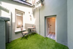 une chambre avec de l'herbe verte, une table et des chaises dans l'établissement Boutique Townhouse, à Westport