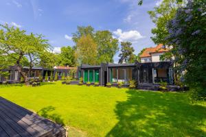 ein Haus mit grünem Rasen davor in der Unterkunft Baltic Beach Houses & Jomas in Jūrmala