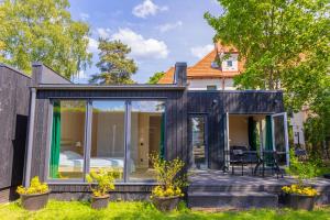 ein schwarzes winziges Haus mit einem Schlafzimmer darin in der Unterkunft Baltic Beach Houses & Jomas in Jūrmala