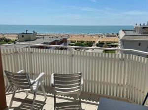 2 stoelen en een tafel op een balkon met uitzicht op het strand bij Hotel Mayer in Bibione