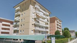 een hoog appartementencomplex naast een straat bij Hotel Mayer in Bibione