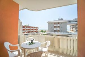 een balkon met een tafel en stoelen en uitzicht op de stad bij Hotel Mayer in Bibione