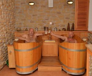 two men are sitting in tubs in a bathroom at Wellness Hotel Svachovka in Český Krumlov