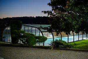 un grande edificio in vetro con piscina di Villa Maria Caetana a Frazão