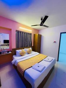 um quarto com uma cama grande e uma ventoinha de tecto em Habitat Inn em Pune