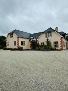 une grande maison avec une allée en face de celle-ci dans l'établissement Ashville Guesthouse, à Westport