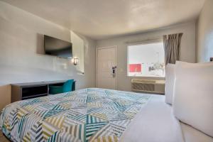 a hotel room with a bed and a window at Motel 6-Albuquerque, NM - Carlisle in Albuquerque