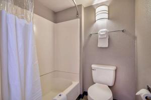 a bathroom with a white toilet and a shower at Motel 6-Albuquerque, NM - Carlisle in Albuquerque