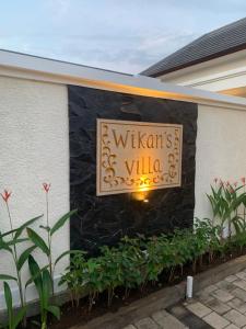 a sign for a wilsidents villa on a building at Wikans Villa in Kuta