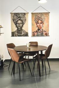 a table and chairs in a room with paintings at Home Away One Bedroom Apartment in Nicosia in Nicosia