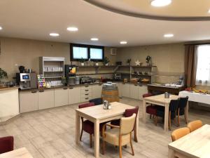 a large kitchen with tables and chairs in a room at Wellness Hotel Svachovka in Český Krumlov