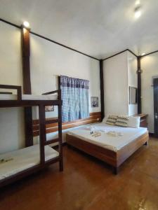 1 dormitorio con 2 literas y ventana en Anaya Inn and Restobar en Panglao City