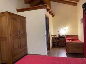 a bedroom with a bed and a desk in a room at Hotel Le Petit Abri in Champoluc