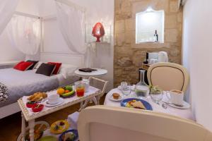 un soggiorno con tavolo e cibo sopra di Le Nicchie luxury rooms a Lecce