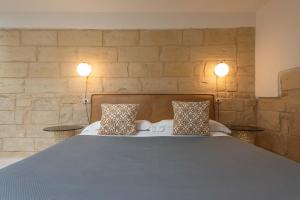 una camera da letto con un grande letto con due cuscini di Le Nicchie luxury rooms a Lecce