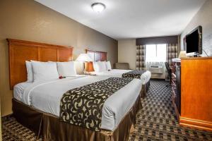 a hotel room with two beds and a flat screen tv at Clarion Inn Renton-Seattle in Renton