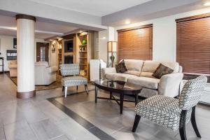 a living room with a couch and a table and chairs at Clarion Inn Renton-Seattle in Renton