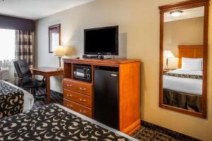 a hotel room with a bed and a television on a dresser at Clarion Inn Renton-Seattle in Renton