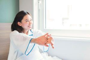 a woman in a white lab coat with a stethoscope around her hand at Comfort Hotel Kitakami in Kitakami