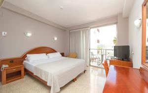 a bedroom with a bed and a television and a balcony at Hotel Marfil in San Antonio