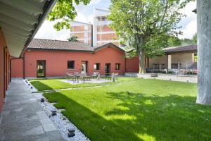 un patio con mesas, sillas y un árbol en Villa Il Platano, en Como