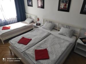 2 camas en una habitación con almohadas rojas. en Apartment Maximilian, en Bratislava