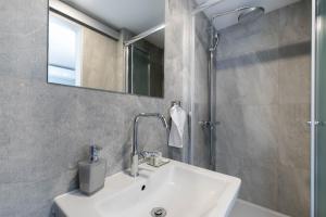 bagno con lavandino, specchio e doccia di Beachfront Apartments Zanic a Podstrana