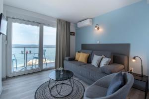 un soggiorno con divano e vista sull'oceano di Beachfront Apartments Zanic a Podstrana