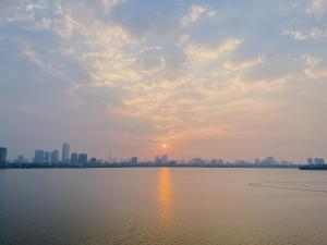 Blick auf die Stadt vom Wasser bei Sonnenuntergang in der Unterkunft Hanoi Home 2 - Lake View Apartment in Hanoi