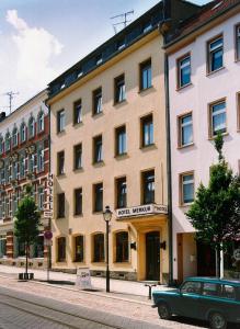 un'auto verde parcheggiata di fronte a un edificio di Hotel Merkur Garni a Zwickau