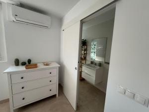 una camera da letto con cassettiera e specchio di Tokyo Rooms Monsul Habitación PREMIUM con baño privado a Almería