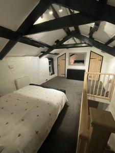 - une chambre mansardée avec un grand lit dans l'établissement Bumblebee Cottage, à Redruth