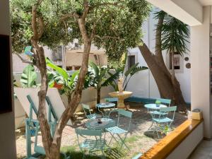 un patio avec des tables et des chaises à côté d'un arbre dans l'établissement Tree of Life Art Hotel, à Agia Marina