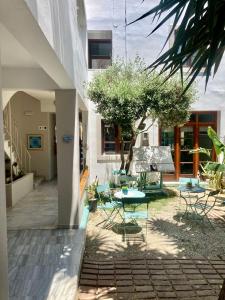 un patio avec des tables et des chaises dans un bâtiment dans l'établissement Tree of Life Art Hotel, à Agia Marina