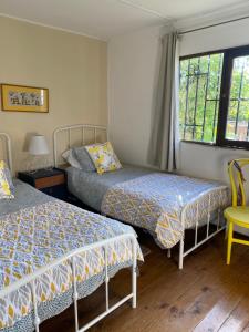 a bedroom with two beds and a window at Casa Doris in Vicuña