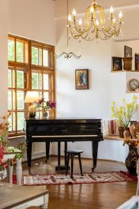 - un piano dans le salon doté d'un lustre dans l'établissement Villa Alba by Akasha Retreat, à Bran