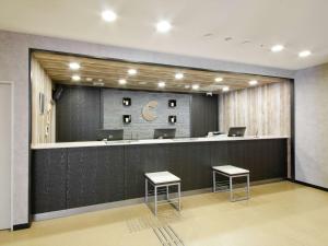 a waiting room with a counter and two stools at Comfort Hotel Kokura in Kitakyushu