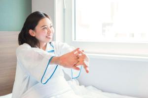 a woman in a white lab coat with a stethoscope at Comfort Hotel Kokura in Kitakyushu