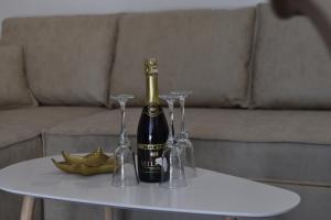 a bottle of champagne and two glasses on a table at KenDar Premium Apartments in Ulcinj