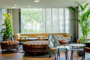 a lobby with a couch and tables and windows at Motel One München - Deutsches Museum in Munich